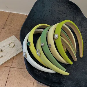 Close-up of assorted green and white padded headbands with elegant rhinestone details