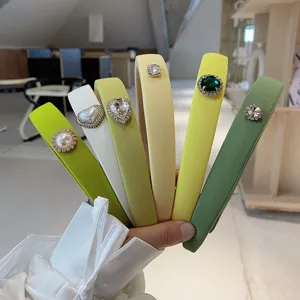 Close-up detail of assorted green and yellow sponge headbands with crystal accents