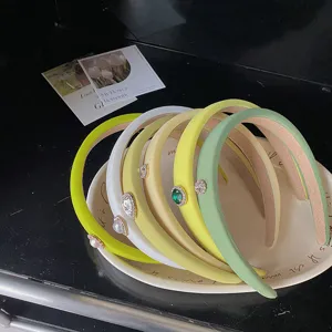Macro view of pastel green padded headbands featuring elegant rhinestone heart accents