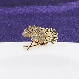 Detailansicht einer funkelnden goldenen Blumenbrosche mit Strasssteinen für Kleidung