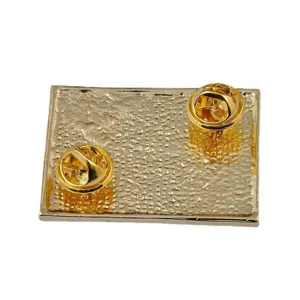 Vue détaillée de l'arrière d'une broche rectangulaire dorée avec deux fermoirs papillon