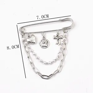 Detailed view of hip hop safety pin brooch with heart, angel charms and pearl chains