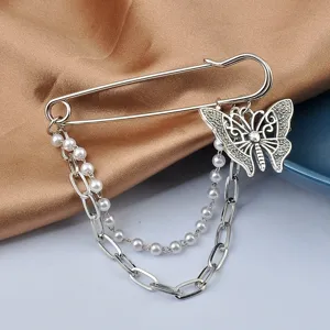 Close-up of silver-toned safety pin brooch with butterfly charm and pearl chain