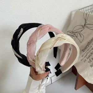 Dettaglio di cerchietti in tessuto intrecciato con decorazioni di perle e strass.