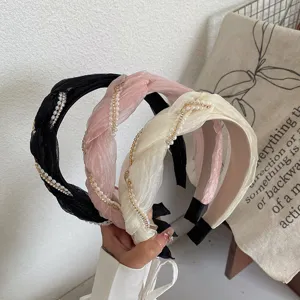 Dettaglio di tre cerchietti intrecciati in tessuto plissettato con perle e strass