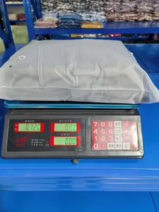 Detail shot showing product packaging and exact weight on an electronic scale in warehouse.