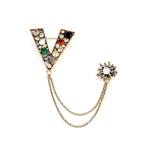 Detail einer barocken V-Brosche mit bunten Strasssteinen und Goldketten