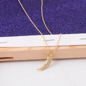 Macro view of 18K gold-plated tooth-shaped pendant necklace with micro-pave crystals