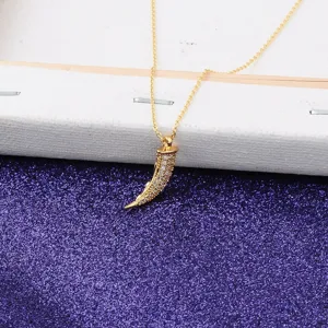 Detailed view of an 18K gold plated tooth pendant necklace with sparkling micro-pave
