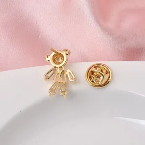 Detail view of the back of a gold teddy bear brooch and its secure butterfly clasp.