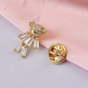 Close-up view of a gold-toned teddy bear brooch adorned with sparkling clear crystals