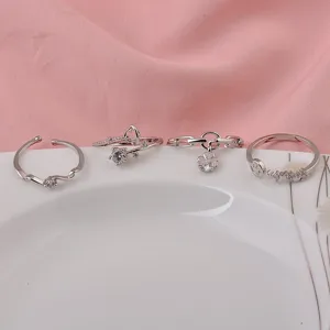 Nahaufnahme von vier silbernen verstellbaren offenen Ringen mit Herz- und Anhängerdesign