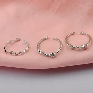 Detailansicht von drei minimalistischen silbernen verstellbaren Ringen in verschiedenen Stilen