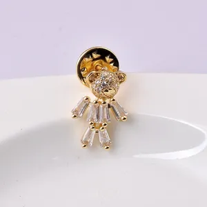 Detailed macro view of a gold teddy bear brooch featuring clear sparkling crystals.