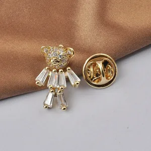 Detailed view of a cute crystal-studded teddy bear brooch in elegant gold finish.