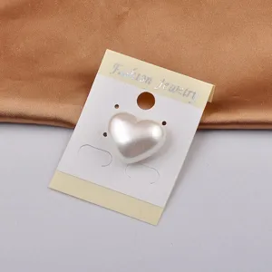 Detailansicht einer weißen herzförmigen Perlen-Magnetbrosche auf Schmuckkarte.