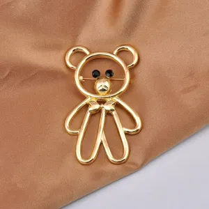 Exquisite detail of a gold-tone bear brooch featuring black crystal eyes on brown silk