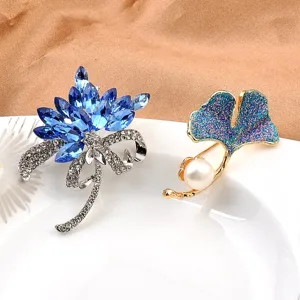 Elegantes Set aus blauem Kristallblumen- und Perlen-Ginkgoblat-Broschen auf Teller