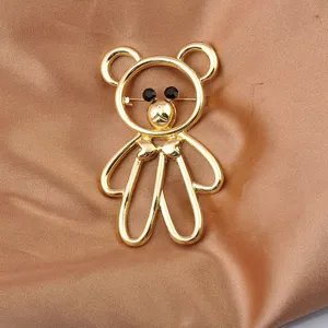 Detailed close-up of a golden hollow teddy bear brooch featuring black rhinestone eyes