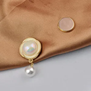 Detailansicht einer eleganten magnetischen Perlenbrosche auf glatter brauner Seide