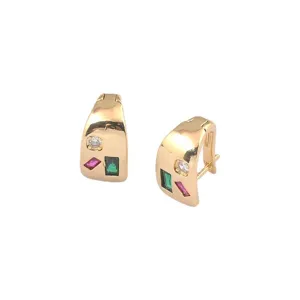 Detailansicht goldener geometrischer Ohrringe mit smaragdgrünen und rosa Steinen