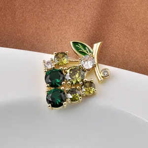 Close-up of elegant grape brooch with green zircons and gold-toned finish