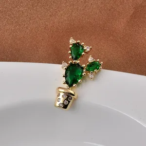 Close-up detail view of a cute gold cactus brooch with sparkling green and white stones