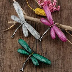 Close-up detail of colorful dragonfly brooches featuring unique stone texture wings