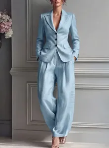 Detailed shot of elegant light blue women's blazer and wide trousers suit set in chic room.