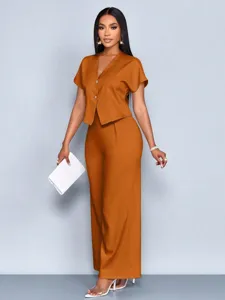 Close-up detail of the stylish short-sleeve top and wide-leg trousers set in orange.