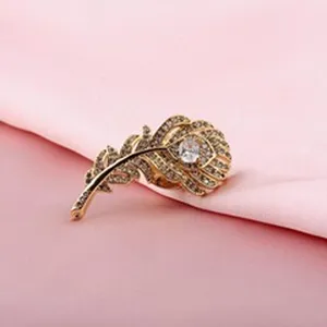Detailansicht der eleganten goldenen Pfauenfedern-Brosche mit funkelnden Kristallen
