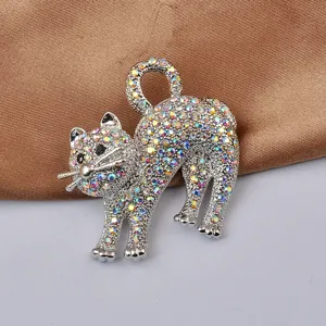 Dettaglio di una spilla a forma di gatto in argento con strass colorati su raso