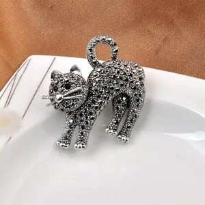 Primo piano di una spilla a forma di gatto argento con cristalli pavé neri