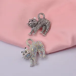 Vista dettagliata di due graziose spille a forma di gatto con strass neri e cangianti