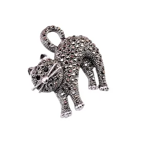 Primo piano dettagliato di un'elegante spilla a forma di gatto con pavé di pietre marcasite
