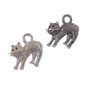 Vista dettagliata di due spille a forma di gatto con strass colorati e neri.