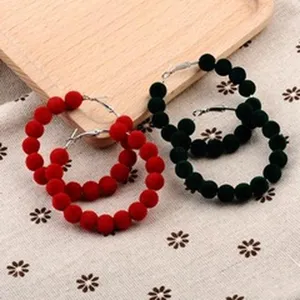 Primer plano de pendientes de aro en piel de visón color rojo y verde oscuro