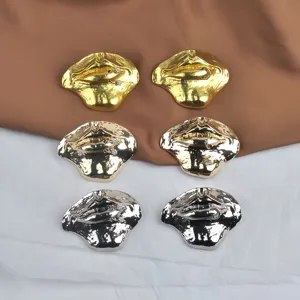 Detailed view of exaggerated metallic lip shape brooches in gold and silver options