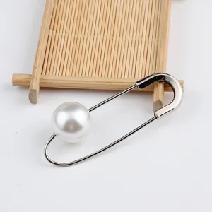 Nahaufnahme einer eleganten silbernen Sicherheitsnadel-Brosche mit einer großen weißen Perle