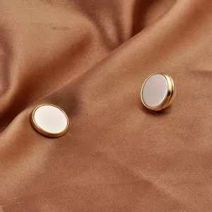 Detail view of magnetic anti-exposure brooch buttons on premium brown silk fabric