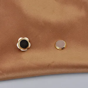 Vista dettagliata di una spilla magnetica a fiore in conchiglia su seta marrone