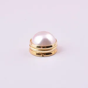 Close-up of elegant white pearl magnetic brooch with golden base