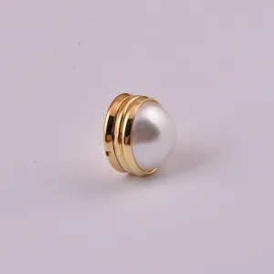 Detailed view of a minimalist magnetic pearl buckle with a gold-tone metal base.