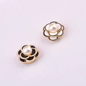 Detailed view of elegant magnetic camellia brooches with pearl embellishments in black and white