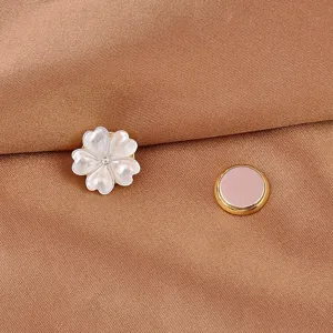 Dettaglio di una spilla magnetica a fiore di conchiglia bianca con supporto dorato