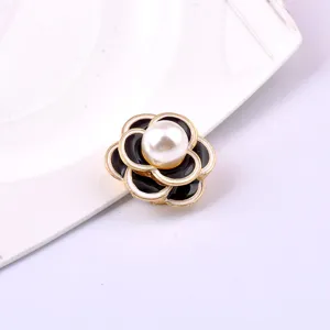 Detailed macro view of a magnetic camellia brooch with pearl center and enamel finish