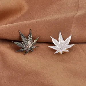 Dettaglio di spille magnetiche a foglia di acero in conchiglia bianca e grigia