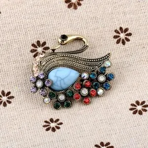 Nahaufnahme einer luxuriösen Vintage-Pfauenbrosche mit bunten Kristallen und blauem Stein