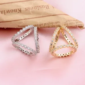 Detail view of luxury triangle scarf buckle with sparkling stones in gold and silver.