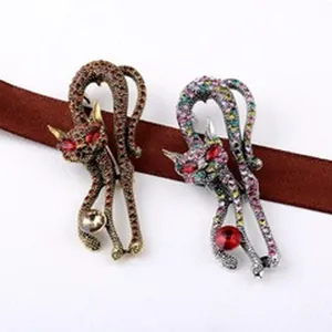 Gedetailleerde weergave van twee luxe met strass steentjes bezette kattenbroches in goud en zilver.